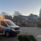 Servicebus van TFK Loodgieter Amsterdam op de Nieuwmarkt bij een storing op eerste kerstdag, met kerstboom op het plein